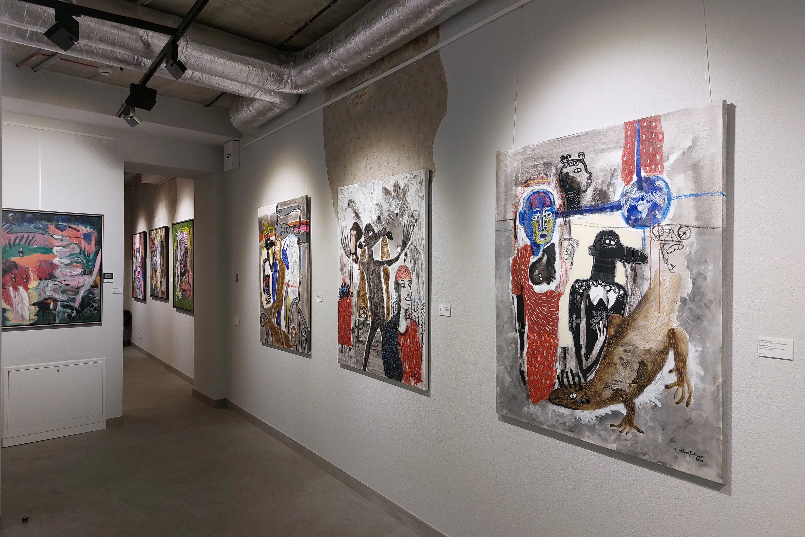 Large paintings on an exhibition wall in the gallery
