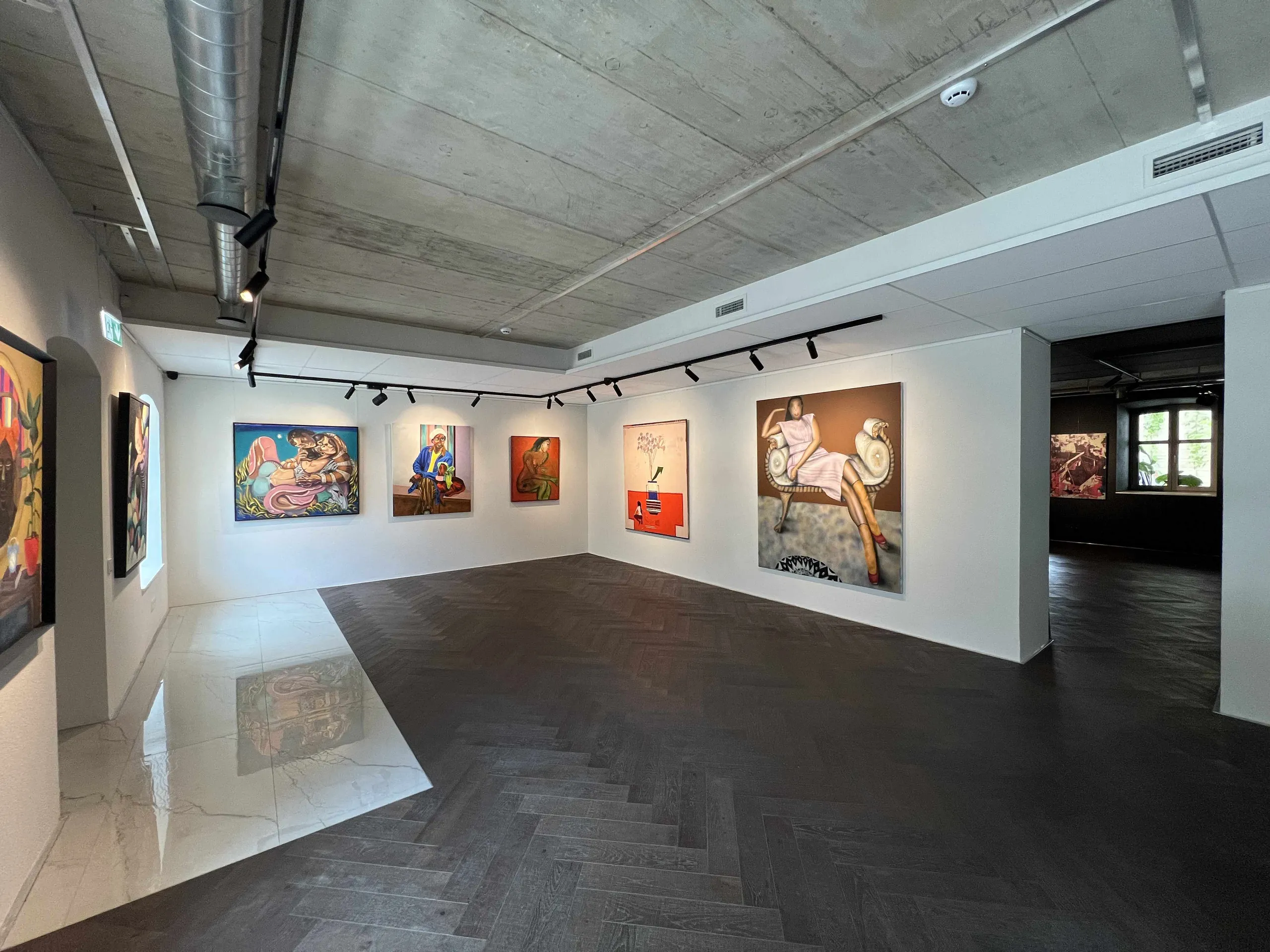 Gallery hall with colourful paintings on white walls